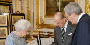 The Queen watches on as Australia’s then high commissioner to the UK Alexander Downer presents the insignia to Prince Philip.