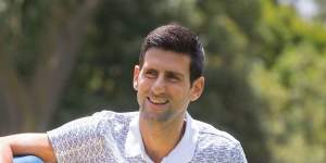 Novak Djokovic poses with his Australian Open trophy in the Royal Botanic Gardens in 2020.