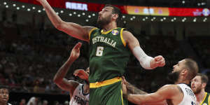 Andrew Bogut of Australia puts up a shot over Amath M’Baye,left,and Evan Fournier of France during their third placing match for the FIBA Basketball World Cup.