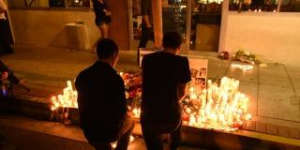 Two men kneel at a makeshift memorial after a killing rampage in Isla Vista near Santa Barbara.
