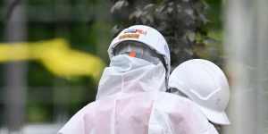 Half a dozen hazmat suit-wearing inspectors are raking through and remove asbestos mulch at Donald McLean Reserve in Spotswood on Friday.