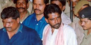 Dara Singh,centre in white,is escorted from the court in Bhubhaneshwar,India,in 2003. His death sentence was later commuted to life.