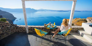 Woman enjoying breakfast with beautiful view over Santorini iStock image for Traveller. Reuse permitted. Greek breakfast,in Greece (Greek Islands)