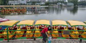 A woman and her child walk in a park in Beijing. China has been doling out tax and housing credits,educational benefits and cash to encourage women to have more children.