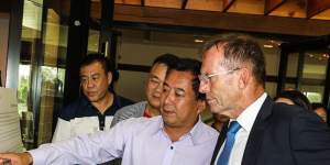 Jack Lam looks on as Tommy Jiang explains the multimillion-dollar redevelopment of the Twin Creeks Golf Club to Tony Abbott last year.