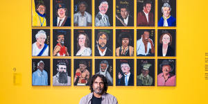 Vincent Namatjira in front of his collection of portraits including Gina Rinehart.
