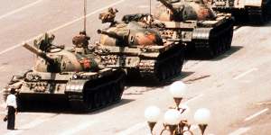 A lone protester clutching a shopping bag prevents a line of tanks from reaching Tiananmen Square,Beijing on June 4,1989.