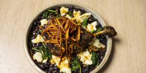 Confit duck with black beans,spinach and clumps of Oaxaca cheese.