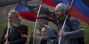 Flying the flag:Pro-Russian activists hold the Donetsk republic flag during celebrations of the Victory Day at a WWII memorial.