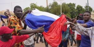 Supporters of mutinous soldiers hold a Russian flag.