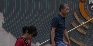 Residents walk past a map showing Evergrande development projects in China.