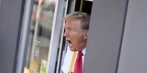 Donald Trump speaks while standing at a drive-thru window during a campaign stop at a McDonald’s.