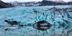 Solheimajokull Glacier's surface is white,but its layers grey and occasionally electric blue.
