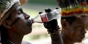 A representative of the Huitoto and Ticuna indigenous communities drinks Coke in Leticia,on Colombia's Amazon river border with Brazil and Peru. A doctor working with the Ticunas has tested positive for coronavirus.