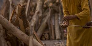 A priest lights a wooden stick as he prepares to perform the last rites of a patient who died of COVID-19 during a mass cremation in New Delhi,India. 