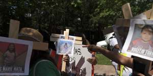 Protesters in Houston carry crosses with photos of victims of the Robb Elementary School shooting in Uvalde,Texas.