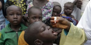 Nigeria - where a polio vaccine is pictured being administered to children - is predicted to become an economic powerhouse.