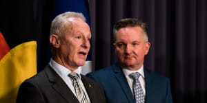 Chris Bowen listens to Greg Mullins at a press conference on Thursday.