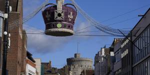 Street lights in the design of a crown hang near Windsor Castle,as the Queen rested after a night in hospital in October.