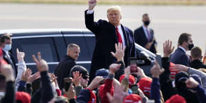 President Donald Trump acknowledges supporters as he leaves a campaign rally at Manchester-Boston regional airport,on Sunday (Monday AEDT).