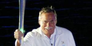 Barassi carries the Queen’s Baton while “walking on water” across the Yarra River for the opening ceremony of the 2006 Commonwealth Games in Melbourne.