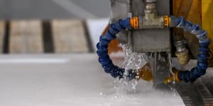 Engineered stone being water cut in a factory.