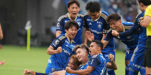 Machida Zelvia players celebrate after scoring a goal.