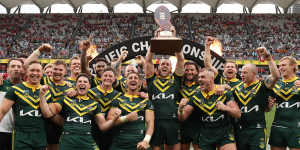 The Kangaroos lift the trophy.