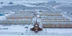 Residential apartment blocks for workers stand beyond a Russian orthodox church near the Udachny diamond mine operated by OAO Alrosa in Udachny,Russia.