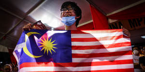A supporter of Malaysia’s opposition leader Anwar Ibrahim holds a Malaysia flag during an election campaign rally on November 16.
