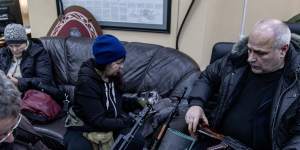 Civilian volunteers check their guns at a territorial defence unit registration office in Kyiv on February 26.