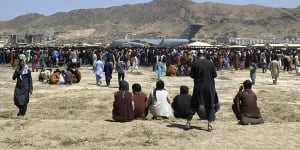 Hundreds of people gather near a US Air Force transport plane at the international airport in Kabul,Afghanistan on Monday.