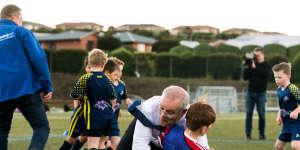 Scott Morrison accidentally takes down Luca Fauvette at a soccer club in Devonport on May 18.