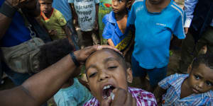A child in Papua New Guinea receives a polio vaccine. The coronavirus outbreak threatens to reverse decades of progress in alleviating poverty.