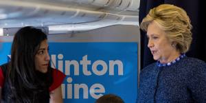 Hillary Clinton speaks with Huma Abedin aboard the campaign plane to Iowa on Friday.