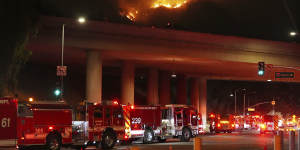 Fire crews sits at Sepulveda Boulevard as fire burns along Interstate 405 in Los Angeles.