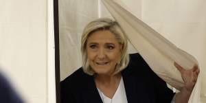French far-right leader Marine Le Pen exits the voting booth while voting for the European election.