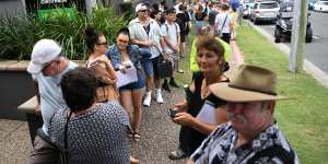 Queues stretch down the street outside a Centrelink office on the Gold Coast. 