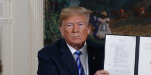President Donald Trump shows a signed memorandum confirming the US withdrawal from the Iran nuclear deal.