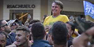 Brazilian presidential candidate Jair Bolsonaro grimaces after being stabbed. 