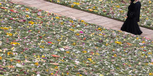 Mourners walk through a sea of flowers following the committal service.