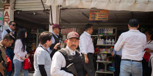 Security men accompany candidate Willy Ochoa as he gives a tour in the municipality of Las Rosas,Mexico.