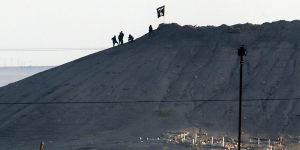 The black flag of Islamic State flies over the town of Kobane in Syria in October 2014.