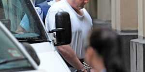 Leslie Alfred Camilleri is lead into the Supreme Court in Melbourne,Thursday,Dec. 5,2013.
