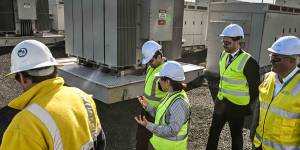 Energy minister Lily D’Ambrosio and workers walk around the Hazelwood big battery.