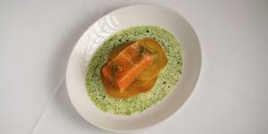 Confit salmon is plated on thin slices of golden beetroot,with a moat of dill crema.