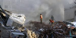 Emergency services work at the site of a destroyed building hit by an airstrike in Damascus,Syria.