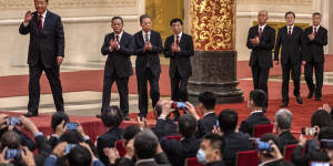 Xi Jinping,left,unveils his new team led by Li Qiang,second from left,in the Great Hall of the People in 2022.