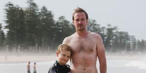 Scott Folkard with his son Jarvis. Mr Folkard rescued a man caught in a rip on Manly beach on Thursday. An experienced swimmer,he heard the man calling for help before dropping below the surface. Mr Folkard emerged covered in bluebottle stings. 