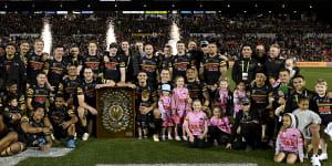 Panthers players and their families with the JJ Giltinan Shield after beating the Cowboys on Saturday night.